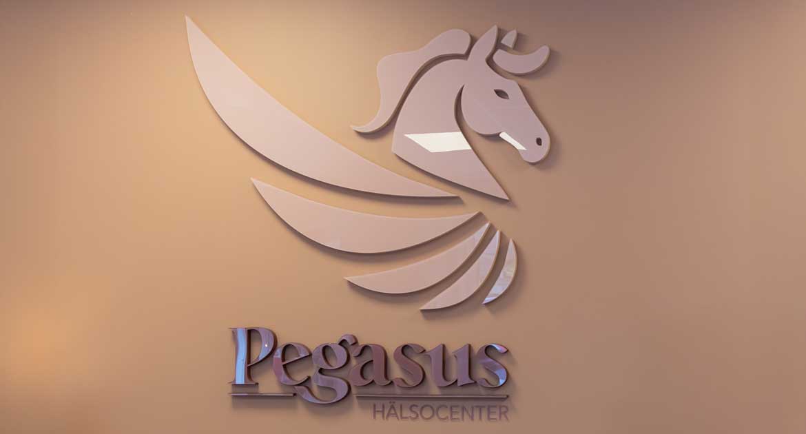 Skylt med Pegasus Hälsocenter logotyp på väggen i kundmottagningen.